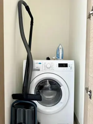a washing machine with a black hose attached to it at Stylish brand new 1 bedroom in Dubai