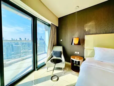 a hotel room with a bed and a large window at Paramount Towers - Elegant Home in Dubai