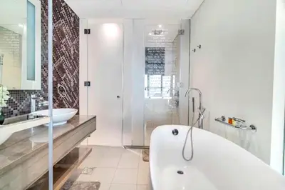 a white bathroom with a tub and a sink at Paramount Towers - Elegant Home in Dubai