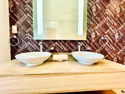 a bathroom with two white bowls on a counter with a mirror at Paramount Towers - Elegant Home in Dubai