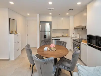 a kitchen with a wooden table and chairs in a kitchen at Brand new 2 Bedroom apartment in Madinat Jumeirah Living in Dubai