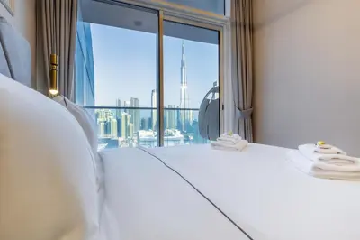 a bedroom with a white bed with a large window at Luxury Top Floor, with full Burj Khalifa View in Dubai