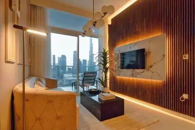 a living room with a couch and a tv on a wall at Luxury Top Floor, with full Burj Khalifa View in Dubai