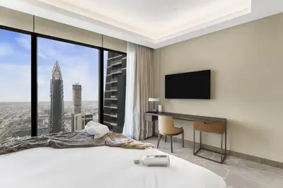 a bedroom with a bed and a desk with a monitor at EDEN'S Homes & Villas - Address Opera District Residences in Dubai