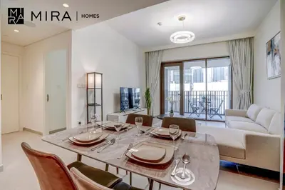 a living room with a table and chairs and a couch at Mira Holiday Homes - Fully furnished 1 bedroom in Creek Harbour in Dubai