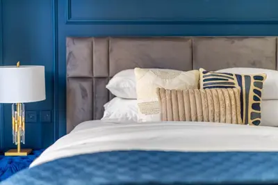 a blue bedroom with a bed with pillows and a blue wall at GuestReady - Stylish blue elegance in La Cote in Dubai