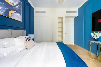 a bedroom with blue walls and a white bed at GuestReady - Stylish blue elegance in La Cote in Dubai