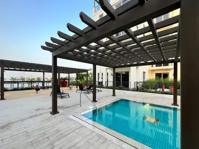 a patio with a swimming pool under a pergola at GuestReady - Stylish blue elegance in La Cote in Dubai