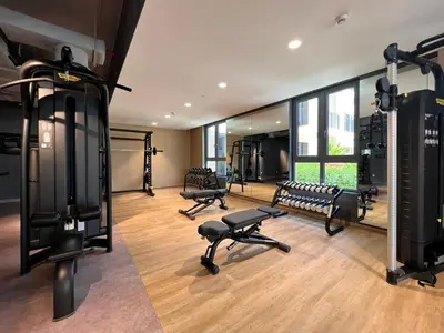a gym with treadmills and benches in a room at GuestReady - Stylish blue elegance in La Cote in Dubai