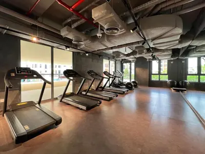 a gym with a row of treadmills and exercise equipment at GuestReady - Stylish blue elegance in La Cote in Dubai