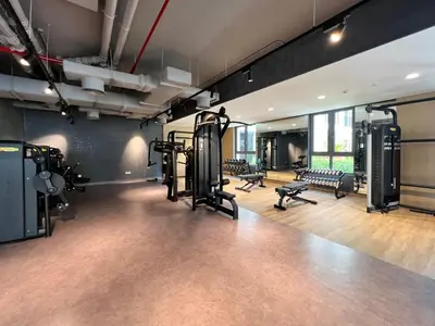 a gym with treadmills and machines in a room at GuestReady - Stylish blue elegance in La Cote in Dubai