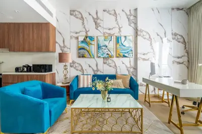 a living room with a blue couch and a table at GuestReady - Stylish blue elegance in La Cote in Dubai