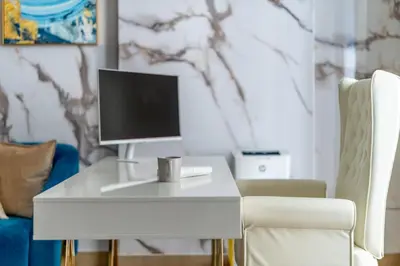 a white desk with a computer on it next to a chair at GuestReady - Stylish blue elegance in La Cote in Dubai