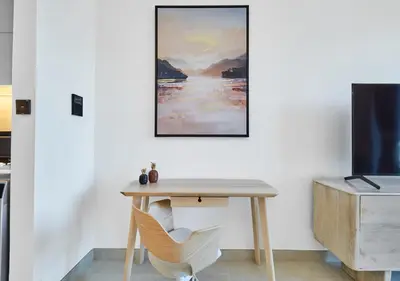 a table and a chair in a room with a painting at Lux Studio in Business Bay -10 mins to Burj Khalifa - Binghatti Canal in Dubai