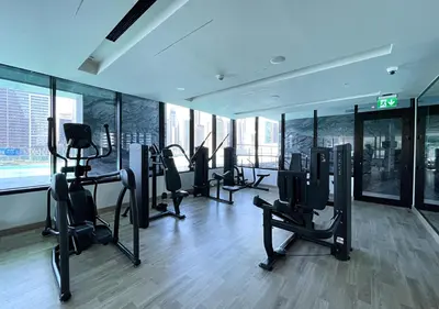 a gym with treadmills and ellipticals in a building at Lux Studio in Business Bay -10 mins to Burj Khalifa - Binghatti Canal in Dubai