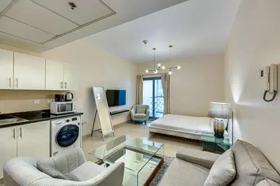 a kitchen and living room with a couch and a table at Bright studio in DIFC near the metro station in Dubai