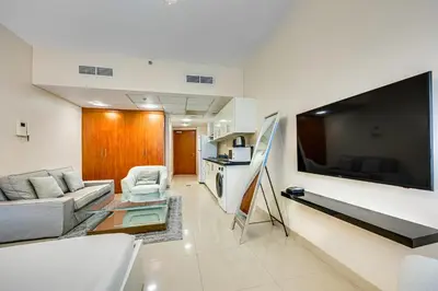 a living room with a couch and a large flat screen tv at Bright studio in DIFC near the metro station in Dubai