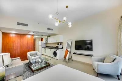 a living room with a couch and chairs and a tv at Bright studio in DIFC near the metro station in Dubai
