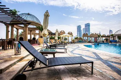 a pool with lounge chairs and an umbrella at Bright studio in DIFC near the metro station in Dubai