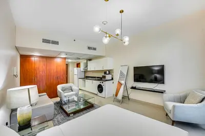 a living room with a couch and chairs and a tv at Bright studio in DIFC near the metro station in Dubai