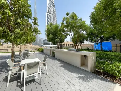 a patio with a table and chairs and trees at Beautiful apartment by Dubai Mall 161BR-2 in Dubai
