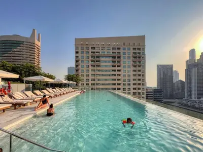 a pool on top of a building with people in the water at GuestReady - Opulent Residence in Dubai Marina in Dubai