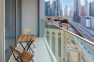 a balcony with two chairs and a view of a city at 2-Bedroom in the Heart of Downtown Dubai in Dubai