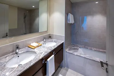 a bathroom with two sinks and a bath tub at 2-Bedroom in the Heart of Downtown Dubai in Dubai