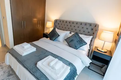 a bedroom with a large bed with two towels on it at 2-Bedroom in the Heart of Downtown Dubai in Dubai
