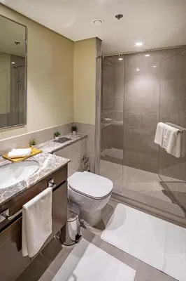a bathroom with a toilet and a glass shower at 2-Bedroom in the Heart of Downtown Dubai in Dubai