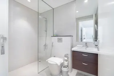 a bathroom with a shower and a toilet and a sink at Stylish Stayz beautiful modern apartment with Burj Khalifa views in Dubai
