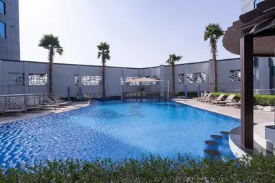 a large swimming pool with palm trees in a building at Stylish Stayz beautiful modern apartment with Burj Khalifa views in Dubai