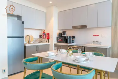 a kitchen with a table and chairs and a refrigerator at Amazing One Bedroom Apartment in Downtown Dubai 167FO2-1 in Dubai