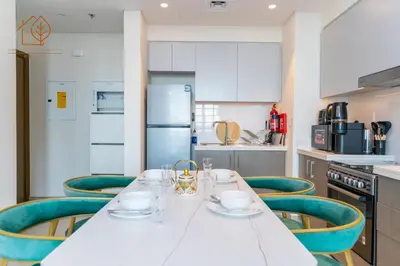 a kitchen with a white table and green chairs at Amazing One Bedroom Apartment in Downtown Dubai 167FO2-1 in Dubai
