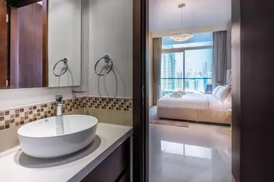 a bathroom with a large white sink and a bed at Luxury Top Floor apt with Full Burj Khalifa view in Dubai