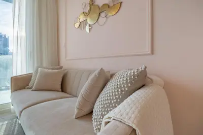 a white couch in a living room with a window at Stylish Stayz 2BR Corner Unit - Yacht & Burj Khalifa Views - close to Dubai Mall in Dubai