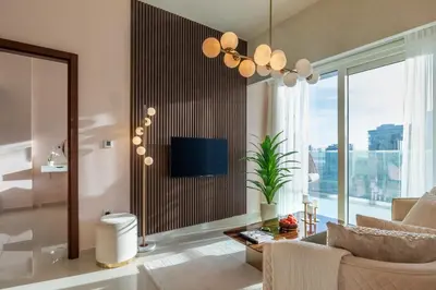 a living room with a couch and a tv at Stylish Stayz 2BR Corner Unit - Yacht & Burj Khalifa Views - close to Dubai Mall in Dubai