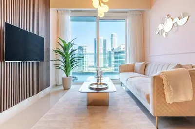 a living room with a couch and a large window at Stylish Stayz 2BR Corner Unit - Yacht & Burj Khalifa Views - close to Dubai Mall in Dubai