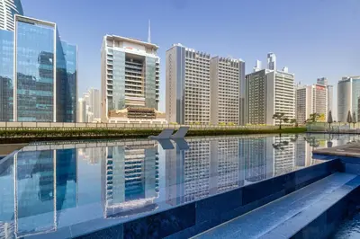 a city skyline with a pool of water and buildings at Stylish high floor apartment with Burj View in Dubai