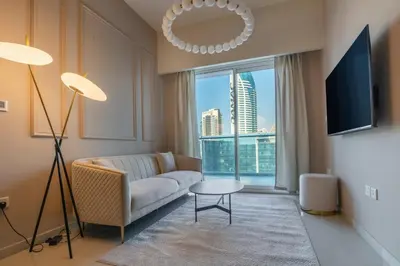 a living room with a couch and a large window at Stylish high floor apartment with Burj View in Dubai