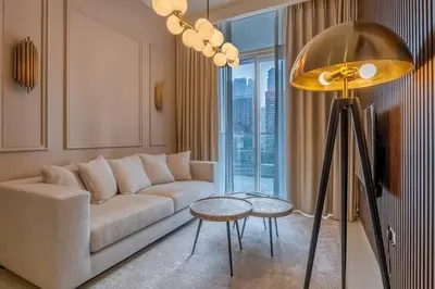 a living room with a white couch and a large window at Stylish Apartment 5 minutes from Dubai Mall with canal view in Dubai