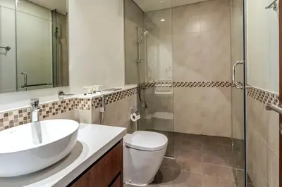 a bathroom with a sink and a toilet and a shower at Stylish Apartment 5 minutes from Dubai Mall with canal view in Dubai