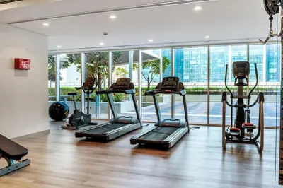a gym with several treadmills and a large window at Stylish Apartment 5 minutes from Dubai Mall with canal view in Dubai