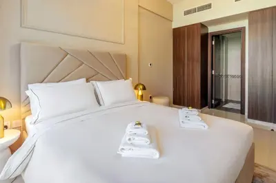 a bedroom with a large white bed with towels on it at Stylish Apartment 5 minutes from Dubai Mall with canal view in Dubai