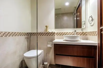a bathroom with a toilet and a sink and a mirror at Stylish Apartment 5 minutes from Dubai Mall with canal view in Dubai