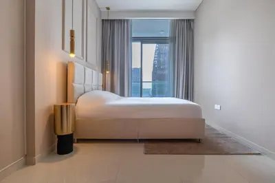 a bedroom with a large bed and a large window at Stylish Apartment 5 minutes from Dubai Mall with canal view in Dubai