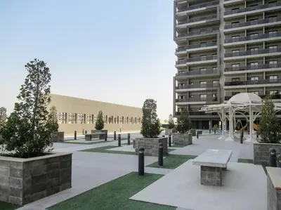 a courtyard with benches and a large building at Frank Porter - Elite 5 Sports Residence in Dubai