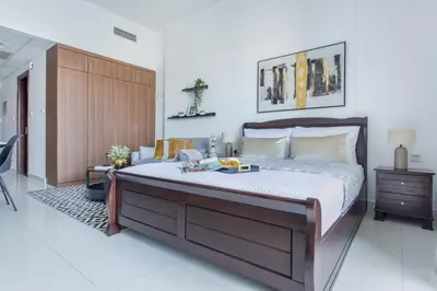 a bedroom with a large bed with a wooden headboard at Frank Porter - Elite 5 Sports Residence in Dubai