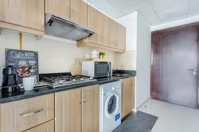 a kitchen with a stove and a washing machine at Frank Porter - Elite 5 Sports Residence in Dubai