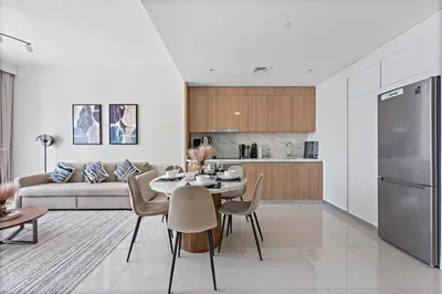 a kitchen and living room with a table and a couch at StoneTree - New Luxury Apartment with Private Beach in Dubai